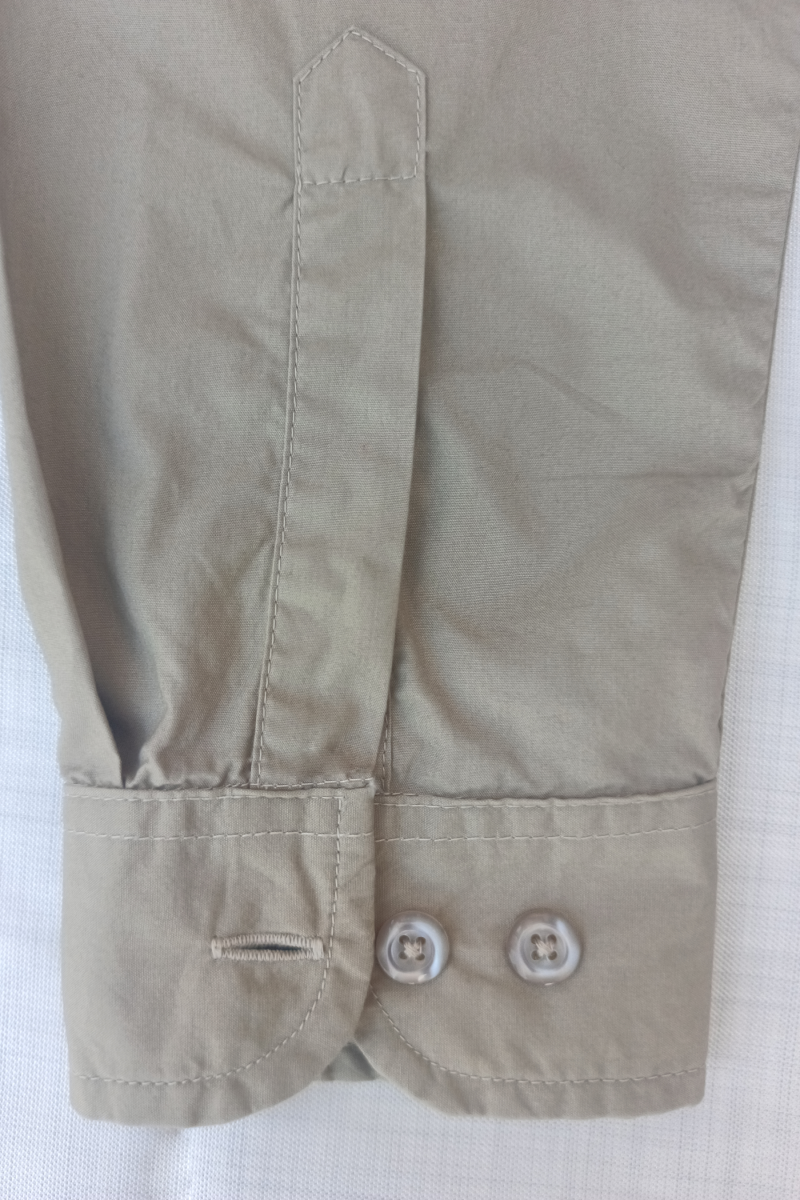 Close-up of a beige shirt with Cuff & button details on a white background