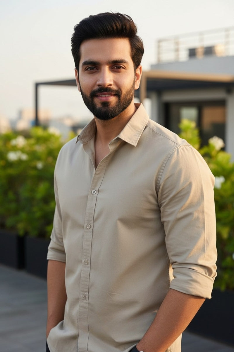Men's beige relaxed fit cotton shirt with chest pocket front right view by Quiet Soul worn by model against balcony background